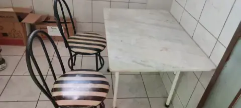 Mesa tampa de mármore com duas cadeiras.